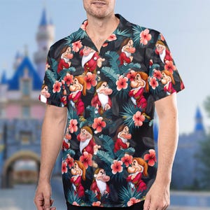 May include: A black button-up shirt with a tropical print featuring cartoon images of the seven dwarfs from the Disney movie Snow White and the Seven Dwarfs. The shirt has a short sleeve and a collared neckline.