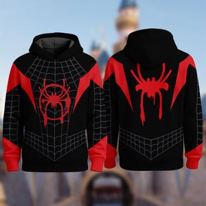 Puede incluir: Sudadera con capucha negra con un dise&ntilde;o rojo con tem&aacute;tica de ara&ntilde;a. La parte delantera presenta un emblema de ara&ntilde;a roja y un patr&oacute;n de telara&ntilde;a, con detalles rojos en los hombros y las mangas. La parte trasera muestra un gran emblema de ara&ntilde;a roja.