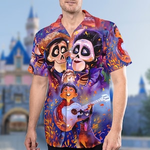May include: A colorful Hawaiian shirt with a print of characters from the animated movie Coco. The shirt features Miguel, Hector, and Mama Imelda. The shirt is a vibrant mix of purple, blue, orange, and yellow.