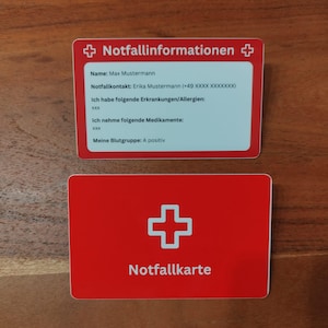 Op de afbeelding: Twee rode en witte noodinformatiekaarten. De bovenste kaart heeft de tekst "Notfallinformationen" en persoonlijke gegevens. De onderste kaart leest "Notfallkarte" met een wit kruissymbool.