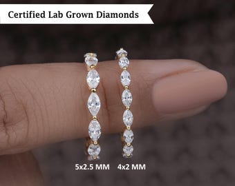 Könnte beinhalten: Zwei goldene Ringe mit Marquise-förmigen, im Labor gezüchteten Diamanten. Der Ring links hat fünf Diamanten, die 5x2,5 mm groß sind. Der Ring rechts hat vier Diamanten, die 4x2 mm groß sind. Zertifizierte, im Labor gezüchtete Diamanten.