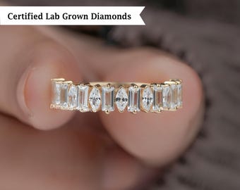 May include: A gold band ring with alternating rectangular and marquise-cut clear gemstones. The ring is set with lab-grown diamonds. The text "Certified Lab Grown Diamonds" is displayed in a white banner.