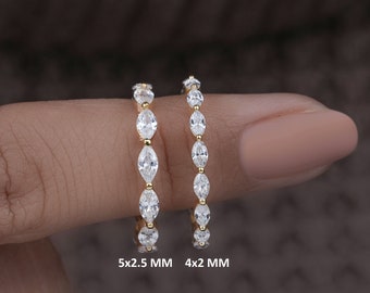 May include: Two gold rings with a row of marquise-shaped diamonds. The ring on the left has larger diamonds, measuring 5x2.5 mm. The ring on the right has smaller diamonds, measuring 4x2 mm.