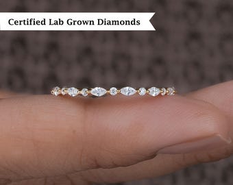 May include: A delicate gold band with a row of marquise-shaped diamonds.  Certified Lab Grown Diamonds.