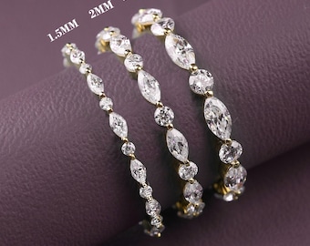May include: Three gold rings featuring alternating marquise and round cut clear stones. The rings are labeled with widths of 1.5MM, 2MM, and 2.5MM, indicating the size of the stones. Each ring displays a delicate band set with sparkling white gems.