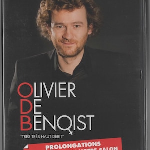 Può includere: Custodia DVD con Olivier de Benoist. La copertina nera mostra il nome del comico in grandi lettere bianche. Il titolo "TRÈS TRÈS HAUT DÉBIT" è in basso, con uno striscione rosso che recita "PROLONGATIONS MAINTENANT DANS VOTRE SALON."