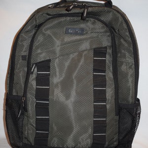 May include: A green and black Calvin Klein backpack with a mesh design and multiple pockets.