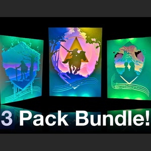 May include: A 3-pack bundle of illuminated paper cut art featuring scenes from the Legend of Zelda video game series. The art is backlit with colorful LED lights and features intricate details.