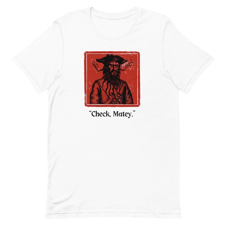 May include: White t-shirt with a red square featuring a black and white illustration of a pirate with a beard and a hat. The text "Check, Matey." is below the image.