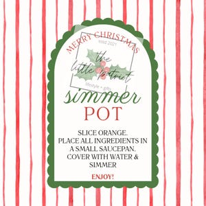 May include: A rectangular label with a scalloped green border on a red and white striped background. The text reads MERRY CHRISTMAS, the little patriot, lifestyle + gifts, SIMMER POT, and instructions to slice orange, add water, and simmer.