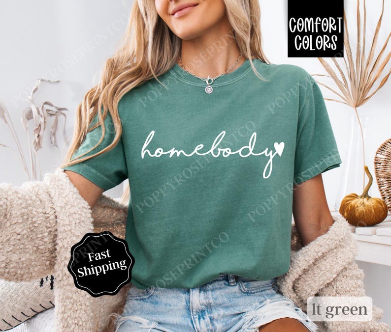 May include: A light green t-shirt with the text "homebody" in white with a small heart next to it.