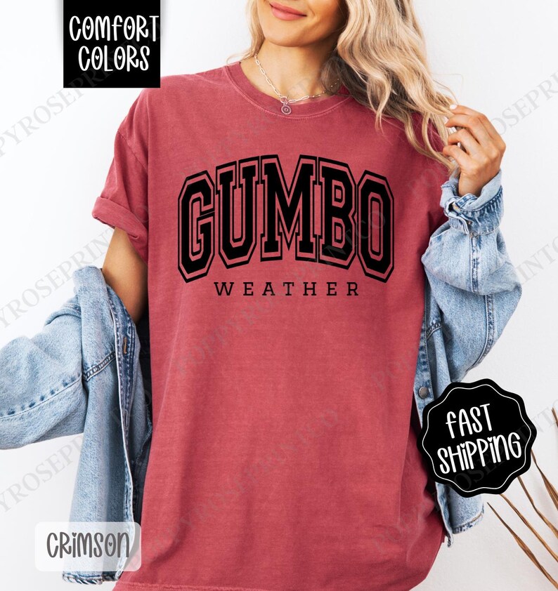 May include: A red t-shirt with the text "GUMBO WEATHER" in black block letters. The shirt is made of a soft, comfortable material.