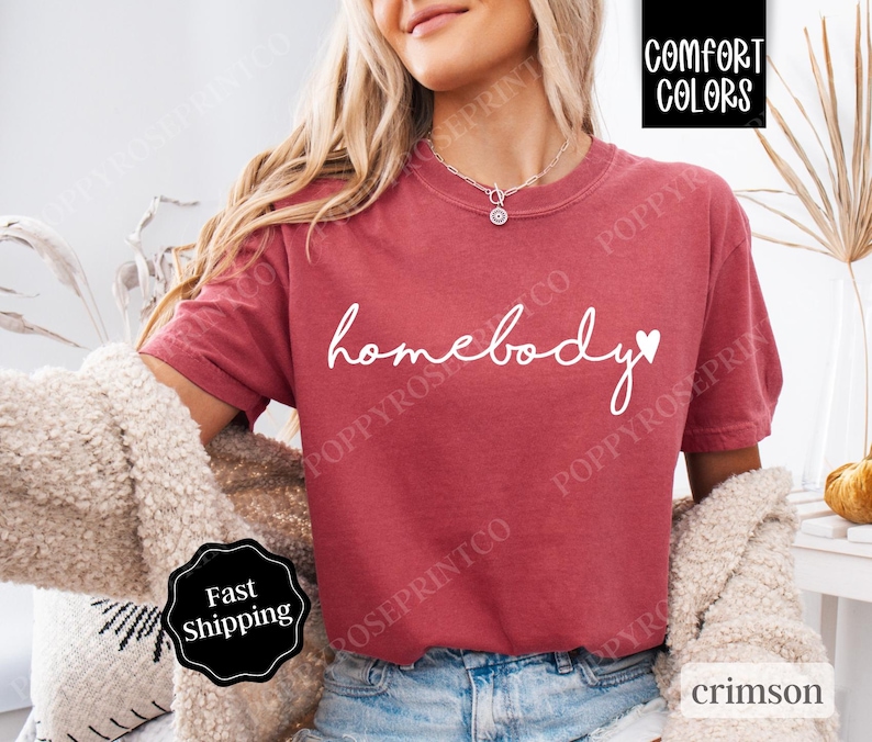May include: A red t-shirt with the text "homebody" in white with a small heart next to it.