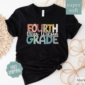May include: Black t-shirt with a colorful graphic that says "Fourth Mrs. Wilson Grade". The shirt is made of a soft, comfortable fabric.