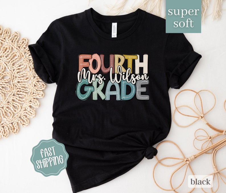 May include: Black t-shirt with a colorful graphic that says "Fourth Mrs. Wilson Grade". The shirt is made of a soft, comfortable fabric.