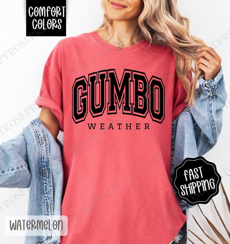 May include: A red t-shirt with the text "GUMBO WEATHER" in black block letters. The shirt is made of a soft, comfortable fabric.
