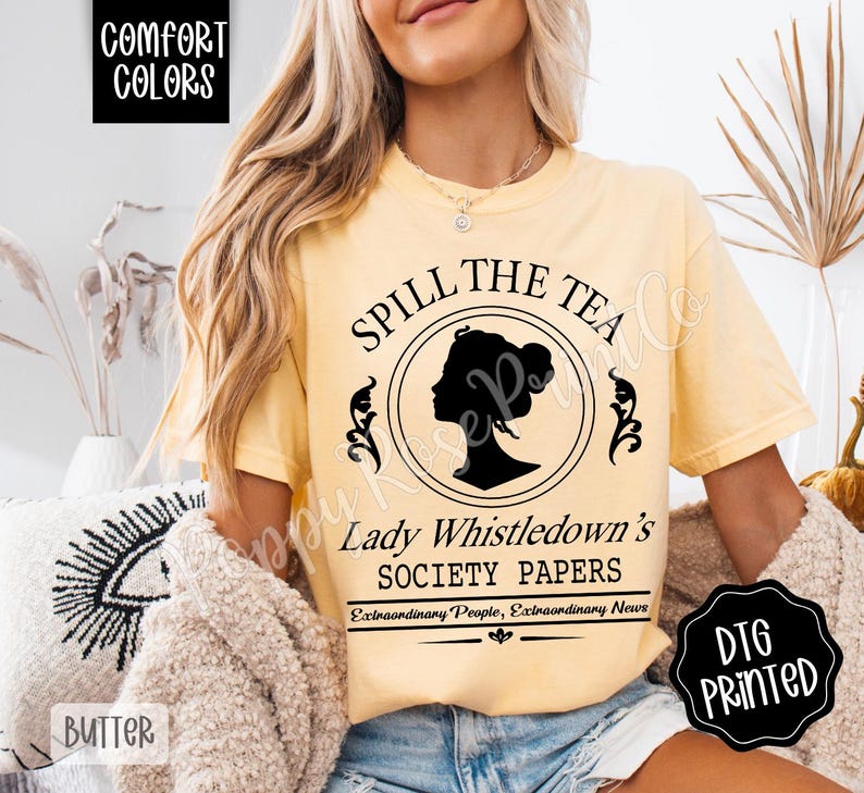 Pu&ograve; includere: T-shirt color burro con la scritta "Spill the Tea" e la silhouette nera del profilo di una donna in un cerchio. La maglietta presenta anche il testo "Lady Whistledown's Society Papers" e "Extraordinary People, Extraordinary News."