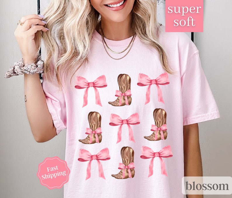 May include: Pink t-shirt with a graphic of brown cowboy boots and pink bows. The text "super soft" and "blossom" are on the shirt.