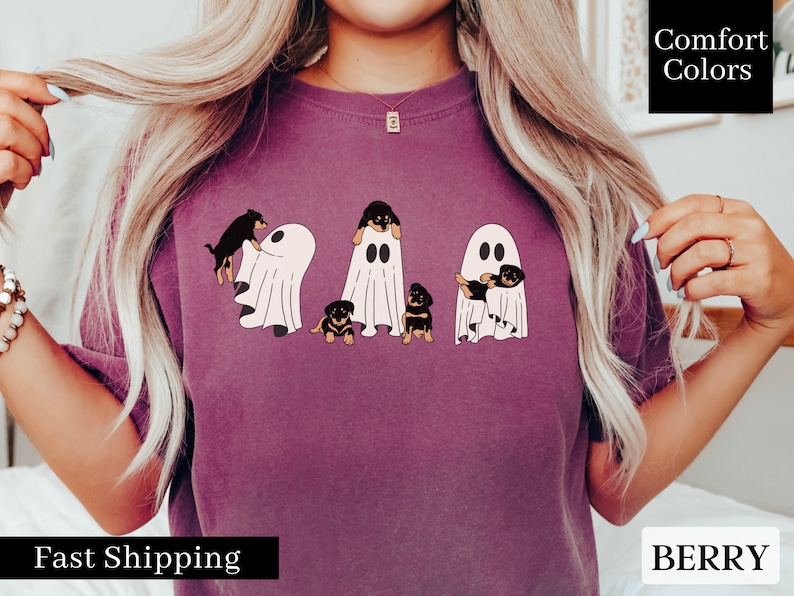 May include: A purple t-shirt with a graphic of five Rottweiler puppies dressed as ghosts. The text "Comfort Colors" is in the upper right corner of the image.