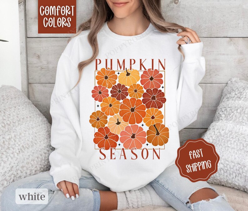 May include: White sweatshirt with a graphic design of orange and brown pumpkins with the text "Pumpkin Season".