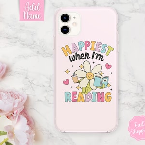May include: A pink iPhone case with a daisy holding a book and a cup of coffee. The text on the case reads "Happiest when I'm reading".