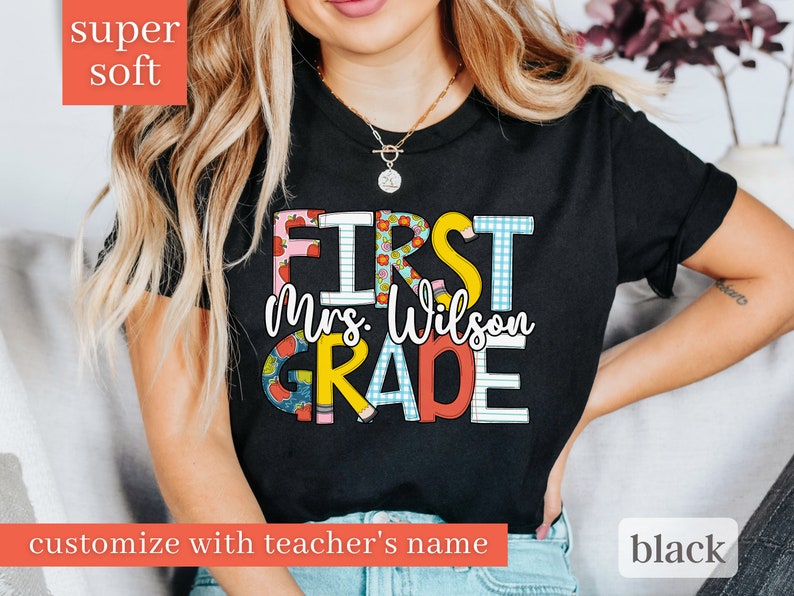 May include: Black t-shirt with the text "First Mrs. Wilson Grade" in colourful letters with a checkered, polka dot, and apple design.  Customise with teacher's name.