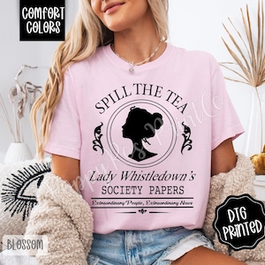 Pu&ograve; includere: T-shirt rosa chiaro con la scritta "SPILL THE TEA" sopra una silhouette nera del profilo di una donna. Sotto la silhouette, il testo recita "Lady Whistledown's SOCIETY PAPERS". La maglietta ha anche il testo "Extraordinary People, Extraordinary News".