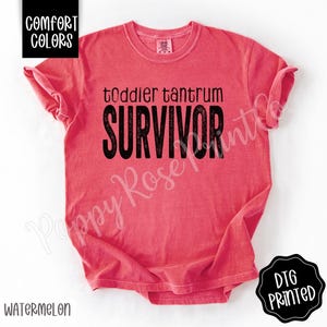 May include: Watermelon-colored t-shirt with the words "toddler tantrum SURVIVOR" in black block letters. The shirt also has the words "Comfort Colors" in a black box in the upper left corner and "DTG PRINTED" in a black circle in the lower right corner.