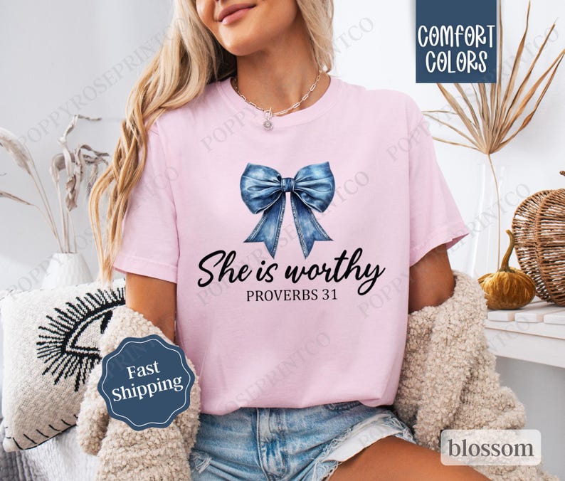 May include: A pink t-shirt with a blue denim bow and the text "She is worthy Proverbs 31" printed on the front.