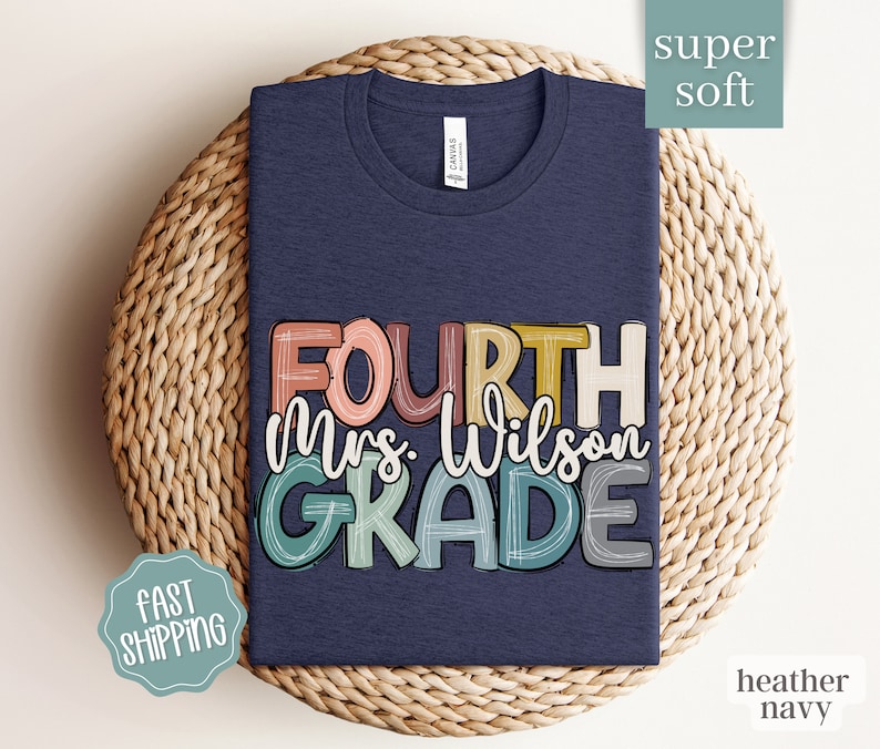May include: A heather navy blue t-shirt with the text "FOURTH Mrs. Wilson GRADE" in colorful, hand-drawn lettering.