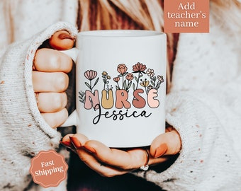 May include: White ceramic mug with a floral design and the word "NURSE" in colorful letters. The name "Jessica" is written below the word "NURSE".