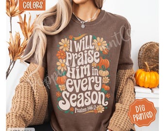 May include: Espresso-colored t-shirt with the text "I Will Praise Him in Every Season" surrounded by flowers and pumpkins. The shirt also has the text "Psalm 146:2". The shirt is part of the Comfort Colors collection and is DTG printed.