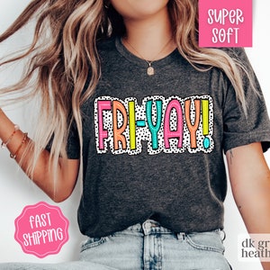 May include: A dark heather grey t-shirt with a colorful "FRI-YAY!" graphic. The graphic has a polka dot pattern and is outlined in black.