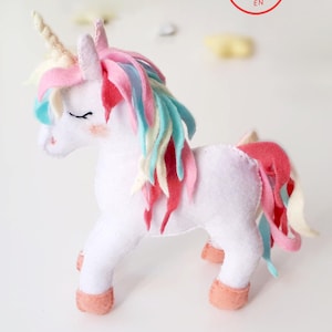 Detailed shot of the unicorn’s face showing embroidered eyes and the decorative thread-wrapped spiral horn.