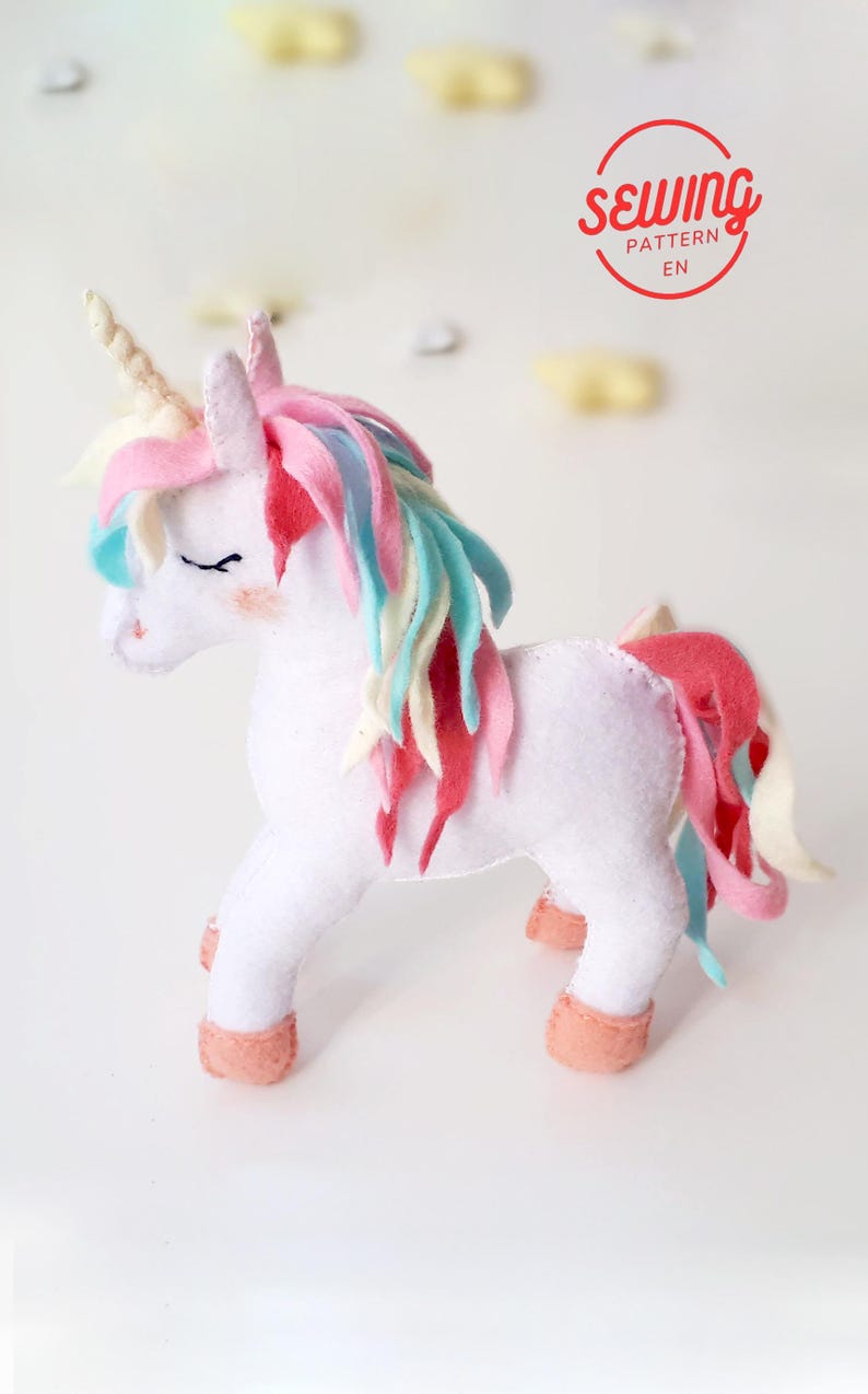 Detailed shot of the unicorn’s face showing embroidered eyes and the decorative thread-wrapped spiral horn.