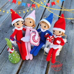May include: Four handmade crochet elf dolls in red, pink, and blue outfits with white trim and pointed hats. One elf holds a candy cane, another a purse, and a third a candy cane. A green Christmas tree is also present.