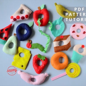 Op de afbeelding: Een set van vilt voedselvormen met gaten in het midden, waaronder een watermeloen, een appel, een banaan, een aardbei, een donut en meer. De vormen zijn kleurrijk en perfect voor een kinderspel. PDF PATTERN + TUTORIAL staat op de afbeelding.