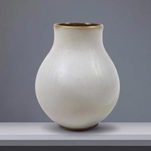Peut inclure: Un vase en céramique bulbeux avec une finition blanc mat lisse qui passe à une teinte brun chaud au niveau du col étroit et de la base circulaire. Le récipient présente un corps large et arrondi qui se rétrécit vers un bord ouvert simple.