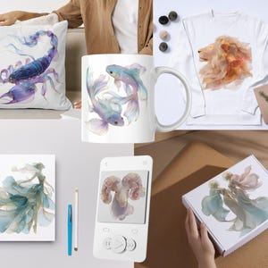 May include: A collection of items featuring watercolor illustrations. Includes a white pillow with a purple scorpion, a white mug with two blue fish, and a white sweatshirt with a lion. Also shown are a notebook, a phone, and a box.