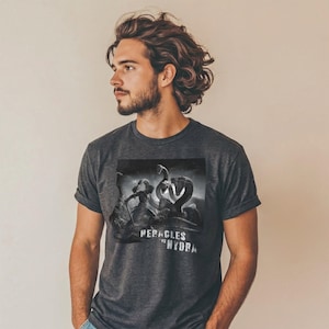 Könnte beinhalten: Dunkelgraues T-Shirt mit einer Schwarz-Weiß-Grafik einer Hydra und dem Text "PERACLES HYDRA". Das T-Shirt hat kurze Ärmel und einen Rundhalsausschnitt.