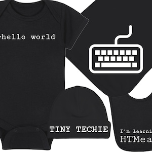 May include: A black baby onesie with the text '>hello world' on the front, a black beanie with the text 'TINY TECHIE' on the front, a black bib with the text 'I'm learning HTML' on the front, and a black square with a white keyboard icon.