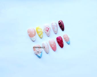 Zomerstrandpers op nagels met schelptextuur en parels