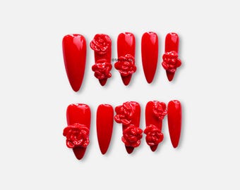Felrode stiletto pers op de nagels met 3D-gebeeldhouwde rozen
