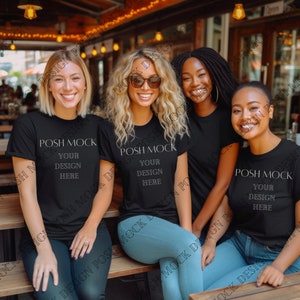 May include: Three women wearing black t-shirts with the text "POSH MOCK YOUR DESIGN HERE" printed on the front. The women are sitting on a wooden bench outdoors.