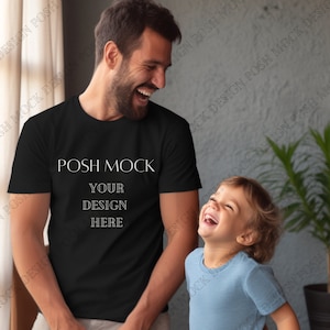 May include: A black t-shirt with the text "POSH MOCK" and "YOUR DESIGN HERE" printed on the front. A man and a child are wearing the shirts and smiling.