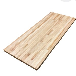 May include: A natural wood butcher block countertop with a light brown color and a straight grain pattern.