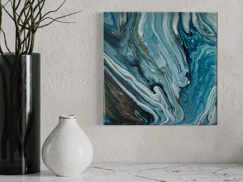 Puede incluir: Pintura abstracta con colores azules, blancos y marrones que se arremolinan. La pintura tiene un aspecto texturizado y marmoleado.