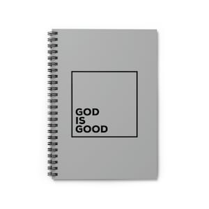 Könnte beinhalten: Graues Spiralnotizbuch mit einem schwarzen quadratischen Rahmen und dem Text "GOD IS GOOD" darin.