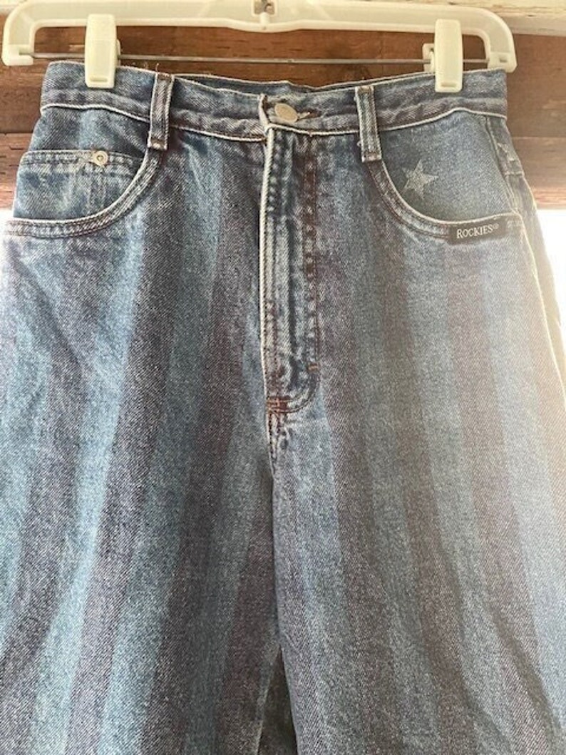 Extremely Rare Vintage Rocky Mountain Jeans with Stars and Stripes! The Detail on the front and back of these jeans is amazing! Even the Rocky Mountain Tag on the Back is Cute. These are a size 26/3 in Exceptional Condition.