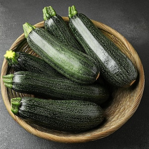 May include: A basket filled with six dark green zucchini, some of which are partially overlapping.
